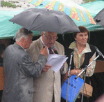 Ректор Хакасского государственного университета Валентин Кузьмин под проливным дождем зачитывает списки поступивших.